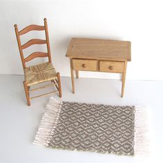 a miniature table and chair next to a rug