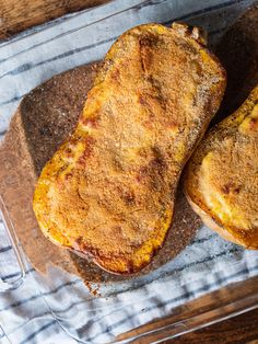 two pieces of bread sitting on top of a wooden cutting board