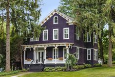 a purple house with white trim on the front porch and stairs leading up to it