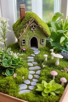 a wooden box filled with lots of green plants and small houses on top of it