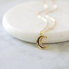 "Beautiful and lovely gold crescent moon necklace made of tiny cubic stone gold crescent moon with skinny gold plated brass chain. Soft and warm looking necklace is good for yourself or gift ! Your necklace will ship in a rudiana gift box. ♥Length 15\" - 20\" ♥Pendent 1/2\" x 1/2\" ♥Gold plated over brass / Cubic Zirconia ♥ Delivery Time Fast shipping within 1 - 3 days ♥ See more Rudiana Accessories Rudiana.etsy.com" Gold Chain With Moon Pendant, Gold Crescent Moon Charm Necklaces, Gold Crescent Moon Phase Charm Necklace, Gold Moon Charm Necklace With Delicate Chain, Gold Charm Necklace With Moon Phase, Gold Plated Crescent Charm Necklaces, Gold Half Moon Charm Necklace With Moon Phase, Dainty Crescent Yellow Gold Charm Necklaces, Gold Half Moon Charm Necklace