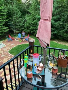 an umbrella is open on a deck with bottles and other items sitting on the table