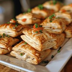 there are many small pastries on the white plate with green garnishes