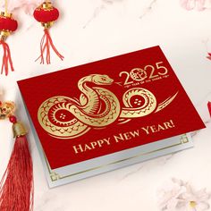 a red and gold new year's card with a snake on it, surrounded by flowers