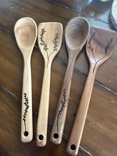 three wooden spoons with designs on them