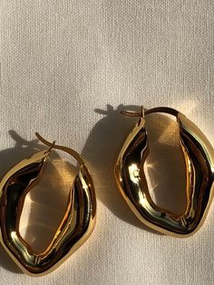 Get ready to be asked about these bold and distinctive hoop earrings every time you wear them. Chunky, organically shaped, eye-catching. Whether for a Friday night date or for a chill Sunday afternoon plan; Featuring a timeless design that will simply elevate all your outfits for years to come. D E T A I L S ~ 24K Gold plating on a high-polished solid brass base ~ Extra layer of tarnish resistance ~ Dimensions: 30 x 22 mm ~ Hinge back closure ~ Hypoallergenic ~ Safe for your skin - Nickel, cadmi Bold Gold Earrings, Gold Chunky Earrings, Chunky Gold Earrings, 2025 Style, Chunky Gold Jewelry, Celine Earrings, Hoop Earrings Handmade, Earrings Gold Hoop, 2024 Wishlist