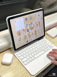 a person is typing on an ipad with a keyboard and mouse in front of them