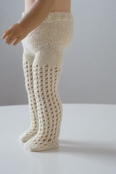 a doll is wearing white knitted leg warmers