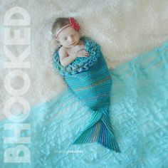 a baby sleeping in a blue crocheted blanket