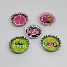 four bottle caps with the words love, what ever and omg printed on them