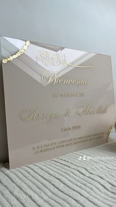 an elegant wedding card with gold foil on the front and back, sitting on top of a bed