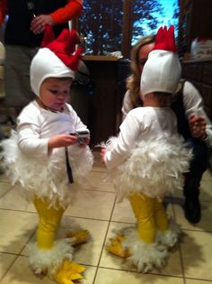 two young children dressed in costumes standing next to each other on tiled floored room floor