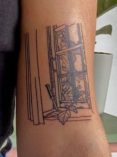 a woman's arm with a tattoo on it that has a window in the background