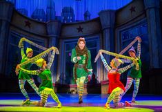 a group of people standing on top of a stage wearing green and yellow outfits,