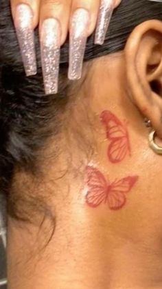 a woman's neck with a butterfly tattoo on her left side behind her ear