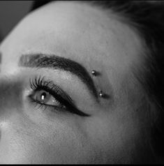 a woman with piercings on her eyes