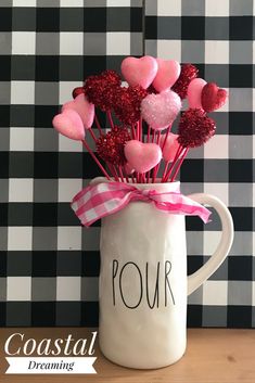 a white mug filled with pink and red heart lollipops