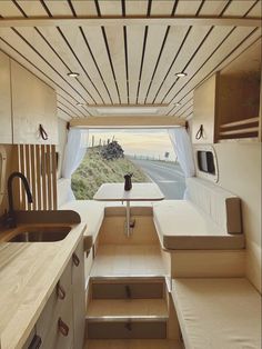 the interior of a camper with stairs leading up to the kitchen and living area