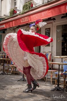 a woman in red and white dress holding an umbrella