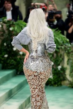 a woman with long white hair is walking down the runway