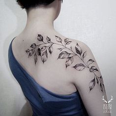 a woman's back shoulder with leaves on her left arm and the upper part of her neck