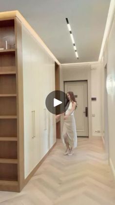 a woman is standing in the middle of an empty room with shelving and shelves