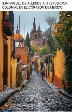 an old cobblestone street with yellow buildings in the background