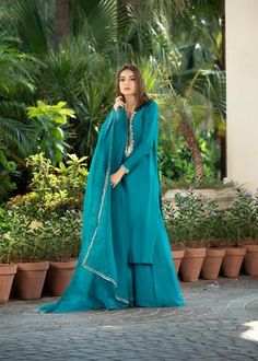 • Turquoise rawsilk handworked shirt with work on neckline (front and back) and sleeves with zardozi and dabka • Paired with matching rawsilk flared pants • Add on a pure katan organza dupatta with gota on four sides (Includes Shirt and pants) Note: 100% advanced payment has to be made for this outfit Blue Organza Lawn Suit With Dabka, Festive Unstitched Turquoise Salwar Kameez, Turquoise Sharara With Resham Embroidery For Eid, Unstitched Turquoise Kurta With Zari Work, Designer Turquoise Kurta For Eid, Designer Turquoise Set For Eid, Festive Turquoise Sheer Dupatta, Turquoise Set For Eid, Turquoise Resham Embroidered Kurta For Eid