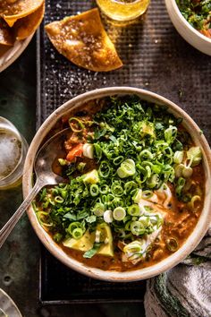 a bowl of soup with tortilla chips and salsa on the side next to it