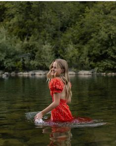 a woman in a red dress standing in the water