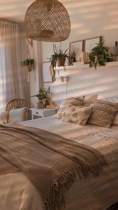 a bed sitting in a bedroom next to a window filled with potted greenery