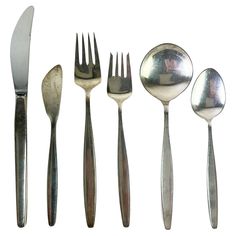 an assortment of silverware including spoons, forks and knives with pictures on them