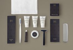 an assortment of men's grooming products displayed on top of a gray surface