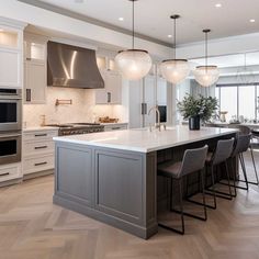 a large kitchen with an island in the middle and lots of counter space on one side