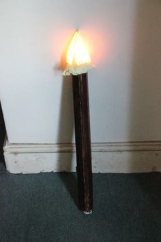 a light that is on top of a wooden pole in the corner of a room