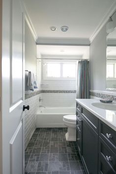 a bathroom with gray tile flooring and white walls