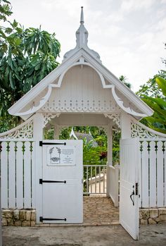 a white wooden structure with an open door