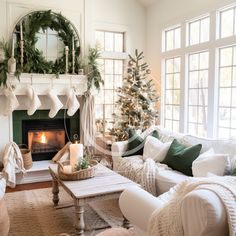 a living room filled with furniture and a fire place in front of a christmas tree