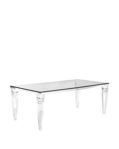 a glass table with acrylic legs on it and a white wall in the background