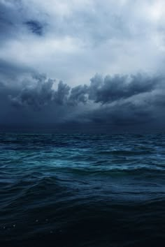 an ocean with dark clouds and blue water