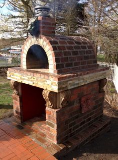 an outdoor brick oven with a statue on top