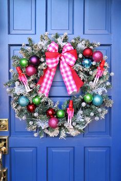 a blue door with a christmas wreath hanging on it's side and ornaments in the front