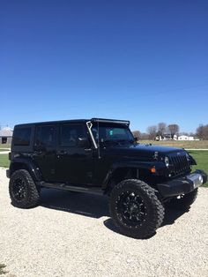 a black jeep parked on top of a gravel road