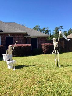 two skeletons are standing in the yard with toilet paper