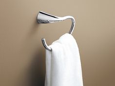 a towel hanging on the side of a wall next to a toilet paper roll holder