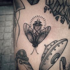 a close up of a person's arm with tattoos on it and various objects