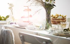 the table is set with flowers and desserts