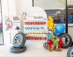 an assortment of toys and balloons on display at a birthday party with mickey mouse theme