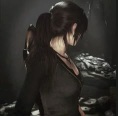 a woman with long black hair standing in front of a dark background and looking at something