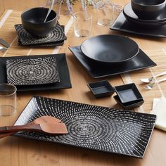 a table set with black plates and silverware